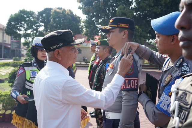 Bupati Asahan H.Surya BSc saat menyemat kan pita ke salah satu peserta apel
