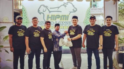 Ketua Umum BPC HIPMI Langsa, M Indra Ibrahim didampingi pengurus saat menyerahkan daging kurban kepada salah satu warga sekitar. (Foto:hariandaerah.com/Sukma)