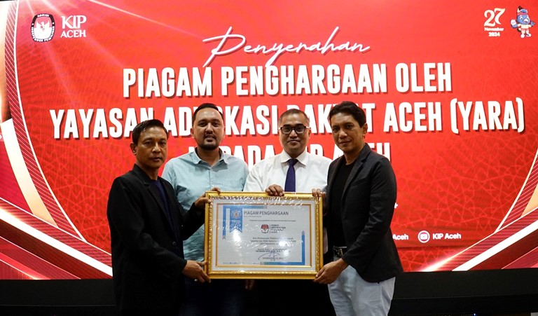 Ketua Yayasan Advokasi Rakyat Aceh (YARA) sekaligus Ketua DPD IKADIN Aceh, Dr. (Cand). Safaruddin, S.H., M.H., (dua dari kanan) menyerakhan piagam penghargaan kepada KIP Aceh yang diterima Agusni AH (satu dari kiri) selaku Ketua KIP Aceh yang berlangsung di Aula KIP Aceh, Senin (9/12/2024). (Foto: Humas Yara)