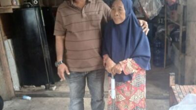 Ketua KPA Wilayah Simeulue, Hermansyah alias Man Kobra bantu nenek Baluki (73), bantuan berupa tongkat itu diserahkan pada Sabtu (22/2/2025). (Foto: Harian Daerah/Kirfan)