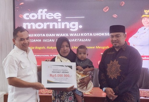 Walikota Lhokseumawe menyerahkan bantuan sosial secara simbolis dari Baitul Mal Kota Lhokseumawe kepada warga-warga yang menderita penyakit kronis dalam acara coffe morning bersama insan pers, Rabu (14/5/2025) di Aula Kantor Wali Kota Lhokseumawe. (Foto: Harian Daerah/Nurmansyah)